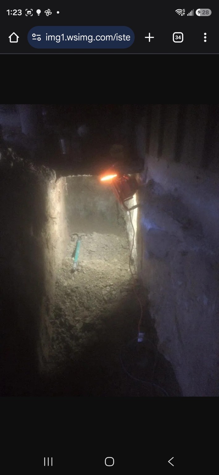 Work-lit excavation beneath the sidewalk for perimeter drain access