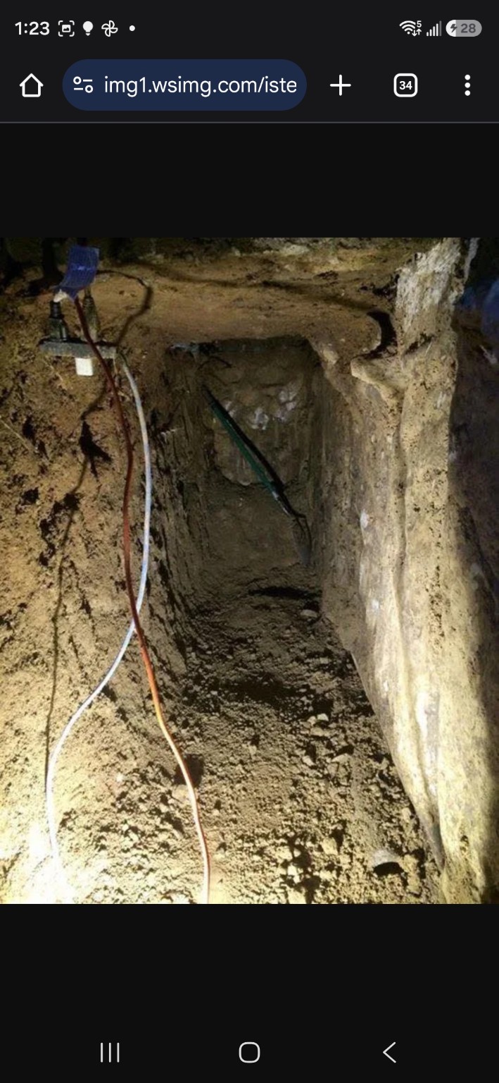 Excavated access beneath an existing sidewalk and deck to reach perimeter drains
